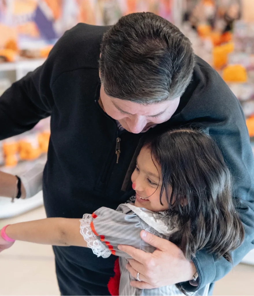 photo of Governor JB Pritzker giving a hug to a small constituent