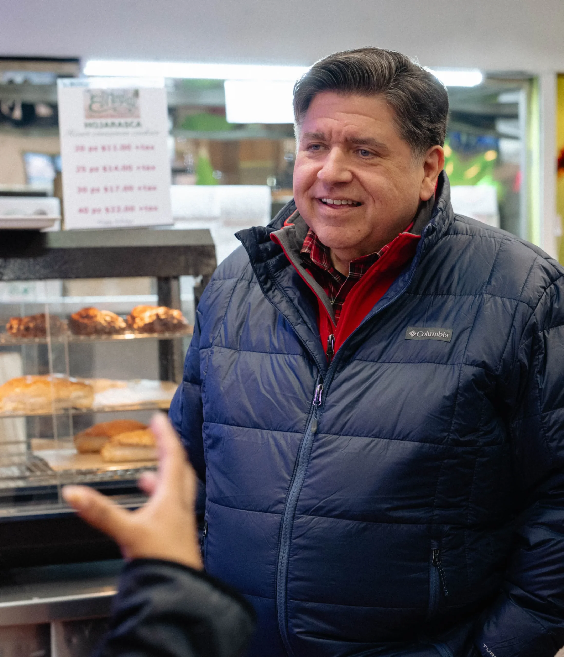 photo of Governor JB Pritzker listening to small business owner