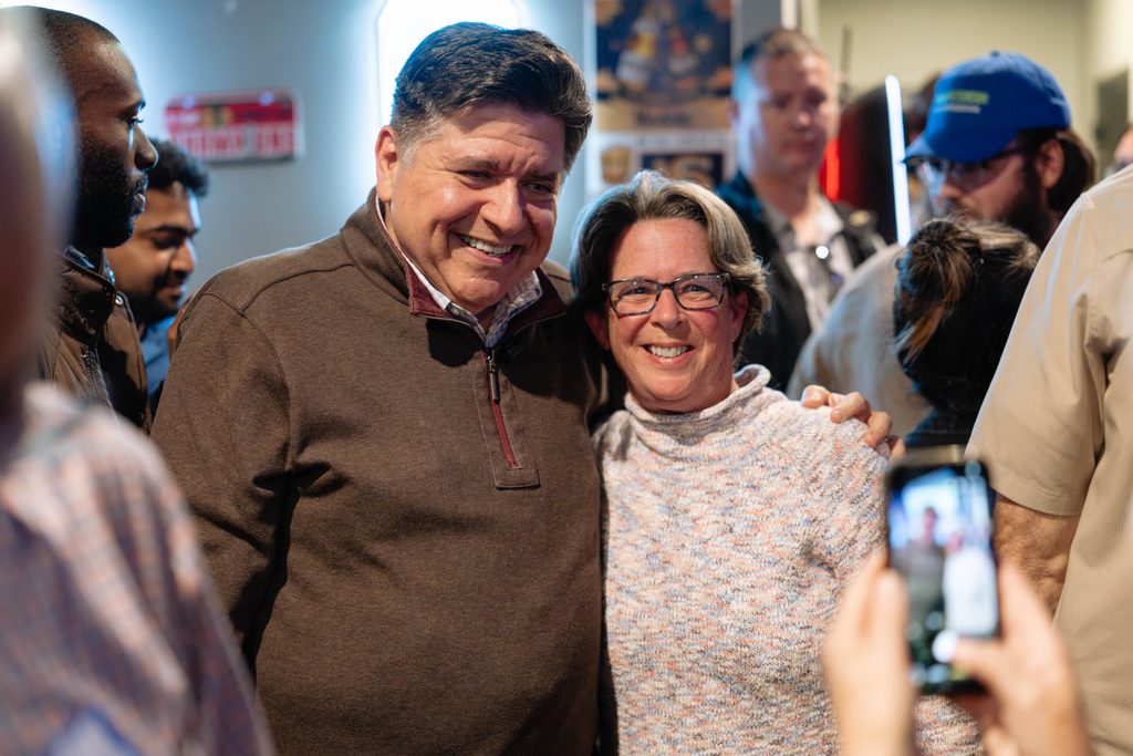 Governor JB Pritzker takes a photo with an attendee at an event in Palatine in support of Democrats in the Northwest suburbs.